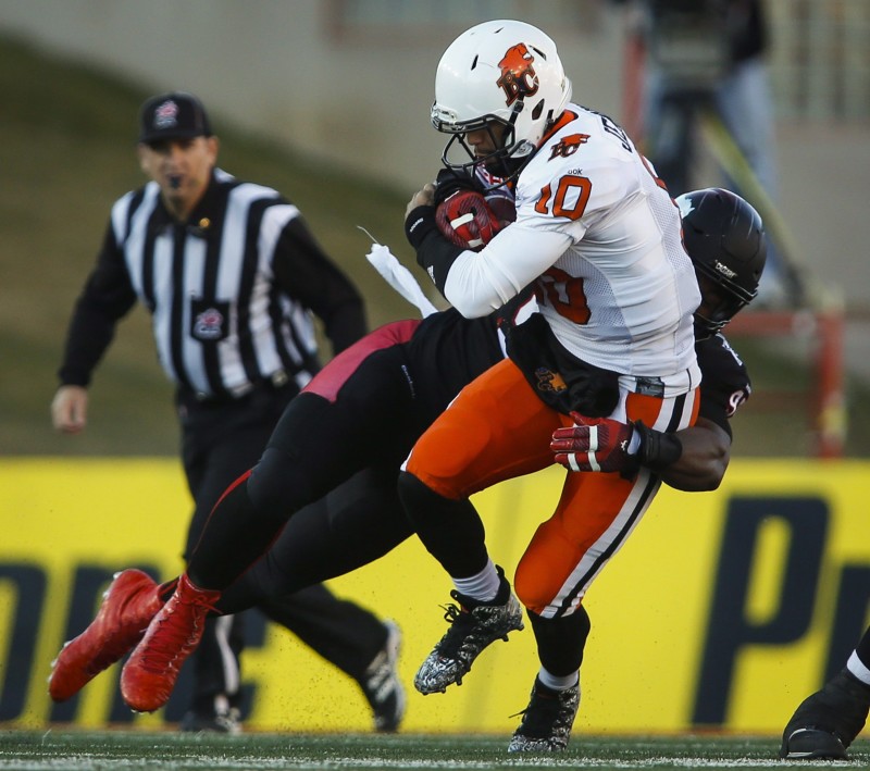 BC Lions quarterback Jonathon Jennings, right, is sacked by Calgary Stampeders' Freddie Bishop III during first half CFL western semifinal football action in Calgary, Sunday, Nov. 15, 2015.THE CANADIAN PRESS/Jeff McIntosh