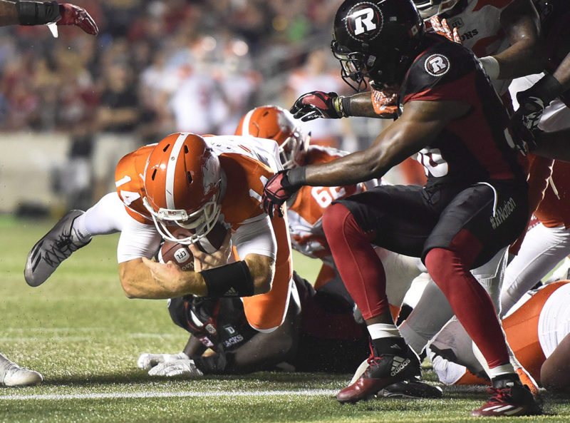 B.C. Lions quarterback Travis Lulay (14) makes a quarterback sneak against the Ottawa Redblacks during second half CFL action on Thursday, Aug. 25, 2016 in Ottawa. THE CANADIAN PRESS/Justin Tang