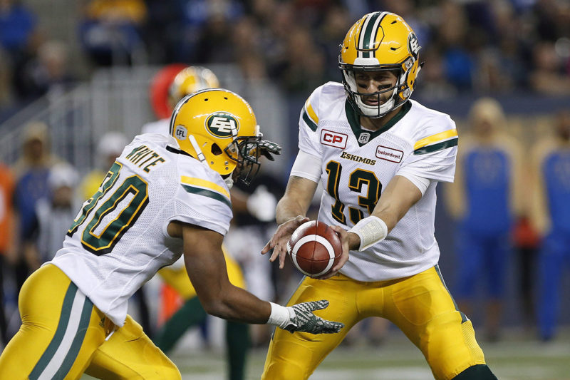Edmonton Eskimos quarterback Mike Reilly (13) hands off to John White (30) during the first half of CFL action against the Winnipeg Blue Bombers in Winnipeg Friday, September 30, 2016. THE CANADIAN PRESS/John Woods