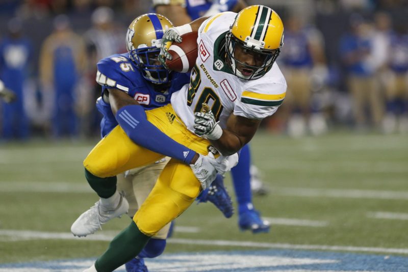 Edmonton Eskimos' John White (30) gets wrapped up by Winnipeg Blue Bombers' Bruce Johnson (25) during the first half of CFL action in Winnipeg Friday, September 30, 2016. THE CANADIAN PRESS/John Woods