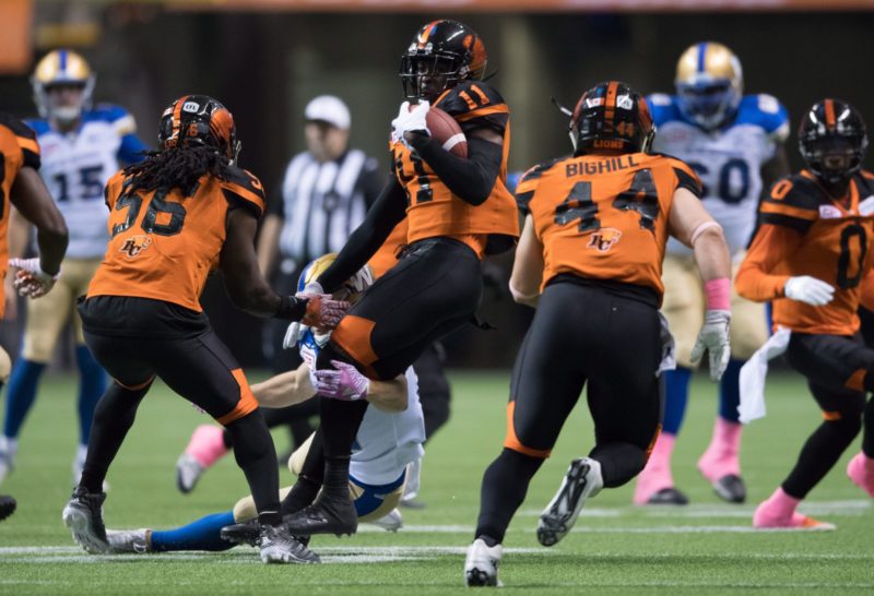 B.C. Lions' Mike Edem, centre, hangs onto the ball after intercepting a Winnipeg Blue Bombers pass during the first half of a CFL football game in Vancouver, B.C., on Friday October 14, 2016. THE CANADIAN PRESS/Darryl Dyck