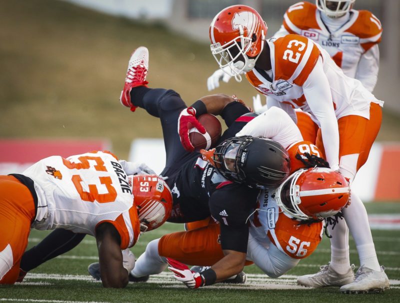 B.C. Lions' Alex Bazzie, left, Solomon Elimimian, right, and Anthony Gaitor, top right, bring down Calgary Stampeders' Lemar Durant during first half CFL western final action, in Calgary on Sunday, Nov. 20, 2016. THE CANADIAN PRESS/Jeff McIntosh