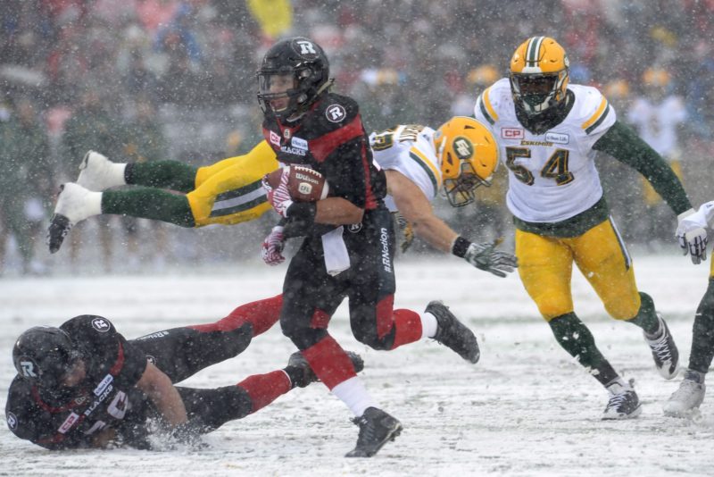 Ottawa RedBlacks' Greg Ellingson (82) makes dodges the Edmonton Eskimos' defenders J.C. Sherritt (47) and Phillip Hunt (54) to deliver a touchdown during first half CFL eastern final action, in Ottawa on Sunday, November 20, 2016. THE CANADIAN PRESS/Adrian Wyld