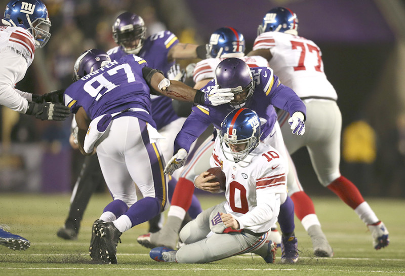 Giants quarterback Eli Manning (10) was sacked for an eight yard loss by Vikings defensive tackle Tom Johnson (92) in the second quarter Sunday night. Giants' Ereck Flowers, left, was penalized on the play for unnecessary roughness on the play.