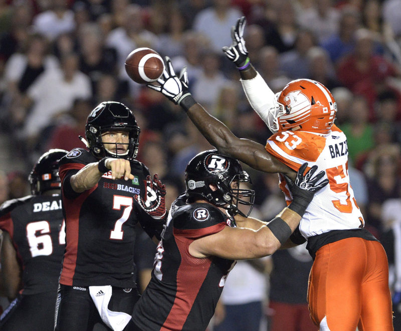 Ottawa Redblacks quarterback Trevor Harris (7) throws the ball past the hands of B.C. Lions' Alex Bazzie (53) during first half CFL action on Thursday, Aug. 25, 2016 in Ottawa. THE CANADIAN PRESS/Justin Tang