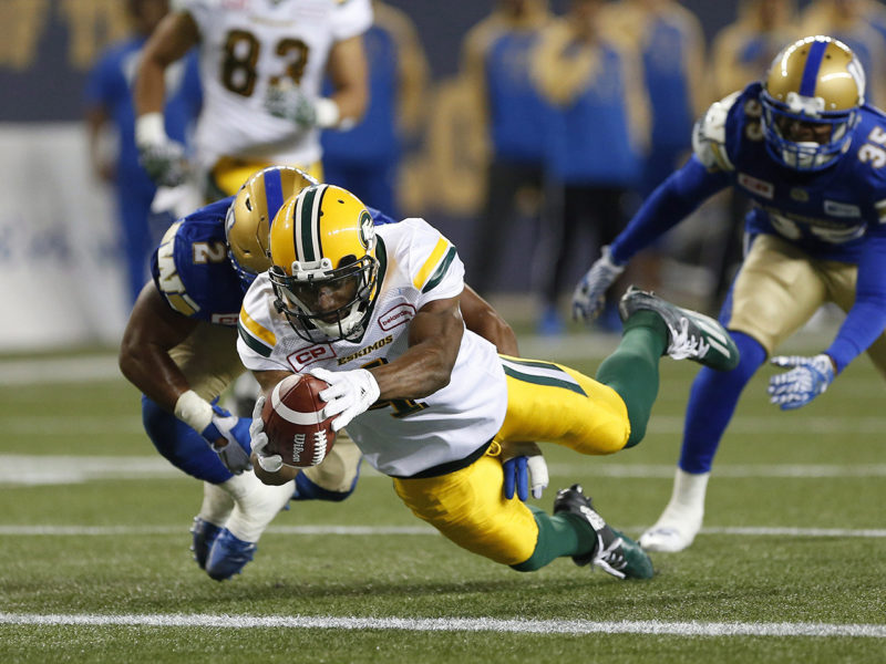 Edmonton Eskimos' Adarius Bowman (4) dives in for the touchdown against Khalil Bass (2) and the Winnipeg Blue Bombers during the first half of CFL action in Winnipeg Friday, September 30, 2016. THE CANADIAN PRESS/John Woods